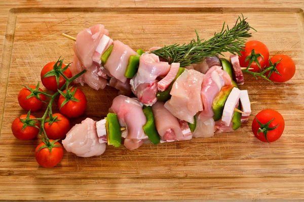 Rohe Spieße Mit Rosmarin Und Tomaten Auf Einem Hölzernen Schneidebrett — Stockfoto