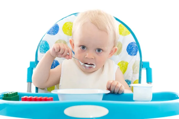 Słodkie Dziecko Uczy Się Jeść Łyżką Siedzi Krześle Białym Tle — Zdjęcie stockowe