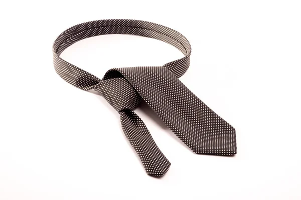 白色背景上白点的黑色领带折叠起来 仿佛在脖子上打个领带结 — 图库照片