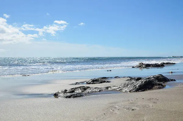 Блестящие Воды Голубое Небо Пляже Песком Плоскими Скалами — стоковое фото