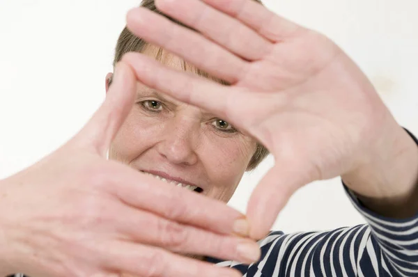 Kopfbild Einer Reifen Frau Die Durch Einen Handrahmen Vor Weißem — Stockfoto