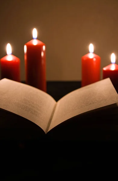 用蜡烛在黑色背景上燃烧圣经 — 图库照片