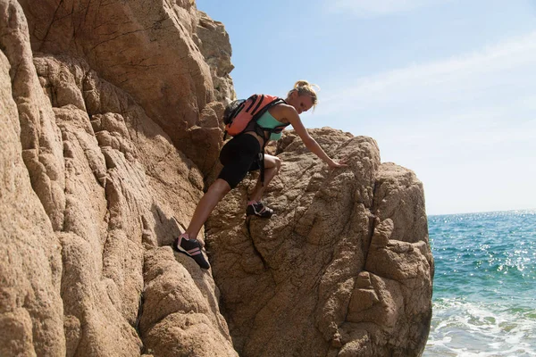 冒険の女の子は崖の上に登り ターゲットを豊かに — ストック写真