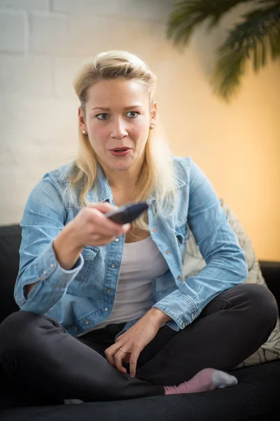 a blond woman with remote control to switch