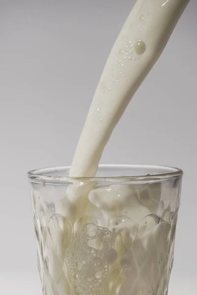 Наливание Молока Стакан Изолированы Белом Фоне — стоковое фото