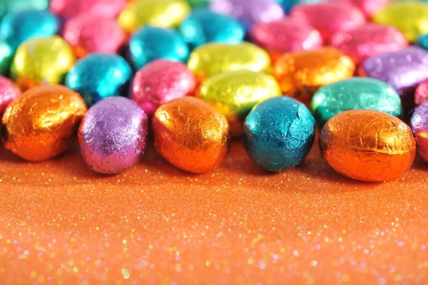 许多色彩艳丽的巧克力彩蛋在闪闪发光的背景下 — 图库照片