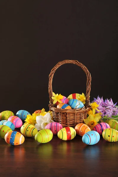 Wiele Malowanych Pisanek Koszykiem Wielkanocnym Żonkilami Brązowym Tle — Zdjęcie stockowe