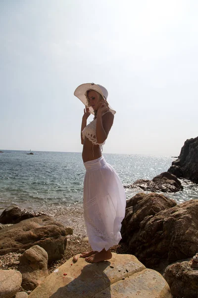 모자를 레이스 드레스를 바위가 해변에 — 스톡 사진