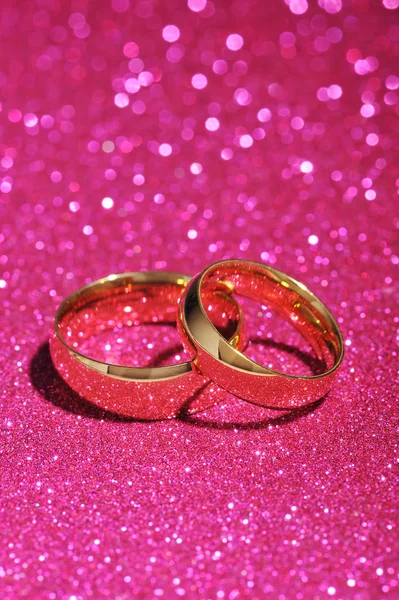 Két Arany Gyűrű Rózsaszín Csillogó Háttér — Stock Fotó