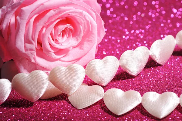necklace of white fabric heart with pink rose on pink glitter background\n