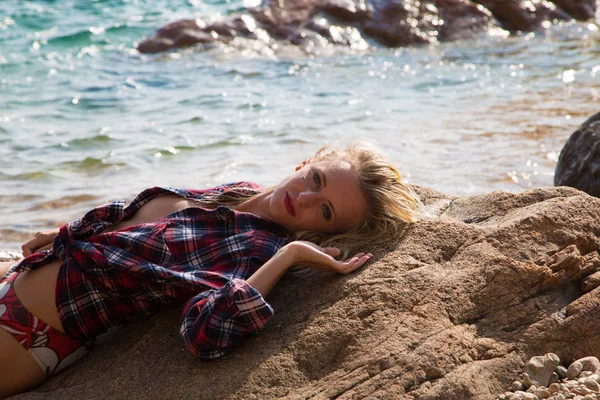 性感的女孩 在岩石海滩上法兰绒衬衫 — 图库照片