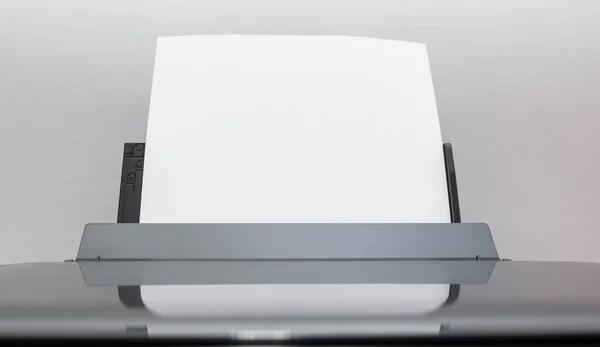 Blank sheets of paper coming out of an computer printer.