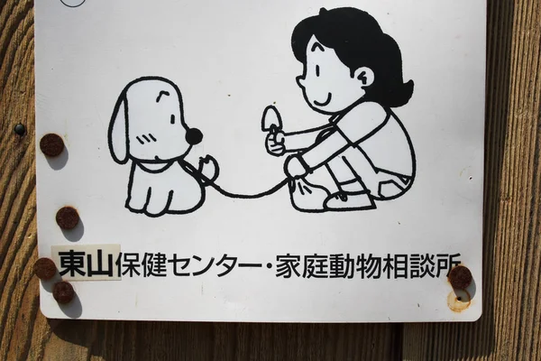 犬の糞の世話をするように求める日本人のキャラクターとサイン — ストック写真