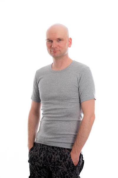 Mężczyzna Łysą Głową Szarej Koszuli Wygląda Przyjaźnie Aparacie — Zdjęcie stockowe