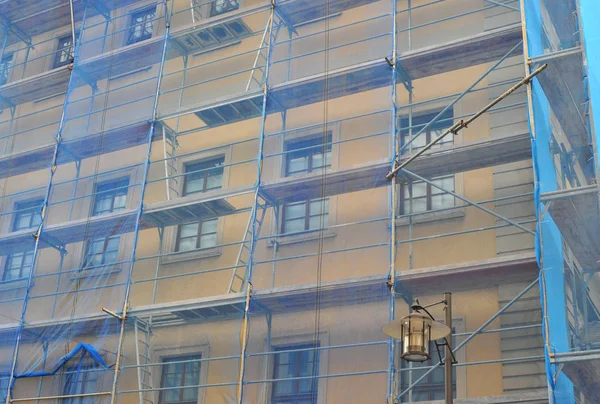 scaffolding covered with blue tarpaulin on an old building
