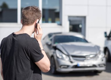young man on the phone after a car accident clipart