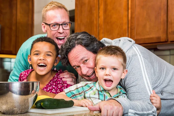 Smiling gay parents with their children in the kitchen