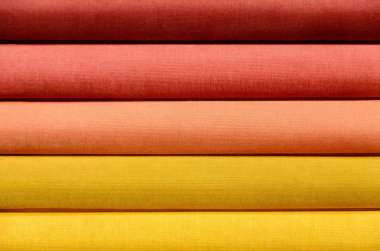 Stack of Book spines covered with linen for background purpose, red, orange, yellow clipart