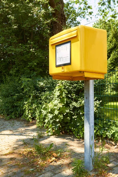 黄色いメールボックスが道の端に立っています — ストック写真