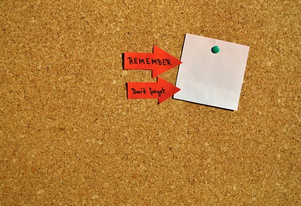 Reminder for an important date on a cork board. White notepad with copy space..