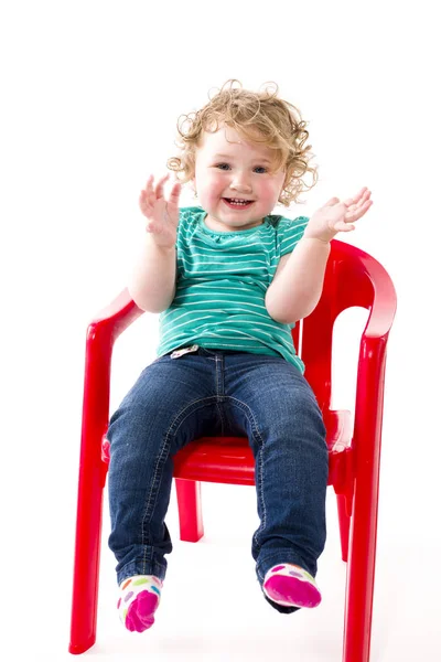 배경에 고립된 채빨간 의자에 개월된 아기가 — 스톡 사진
