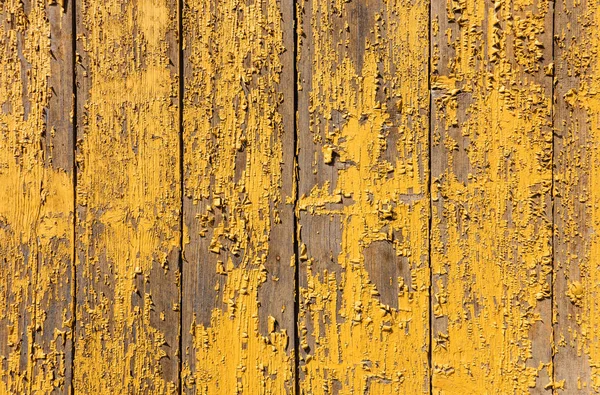 yellow paint peeling off a board wall