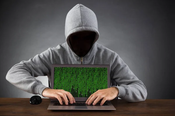 Mann Mit Kapuze Und Maske Hackt Laptop Holztisch — Stockfoto