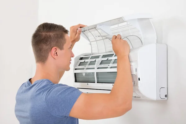 Young Man Checking Air Conditioner Mounted White Wall — Stock Photo, Image