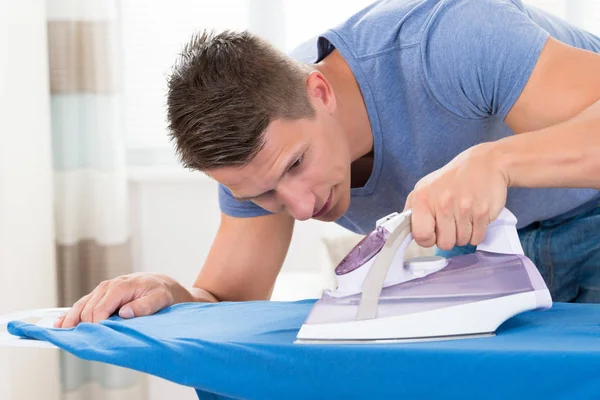 Hombre Joven Planchando Ropa Con Plancha Eléctrica — Foto de Stock