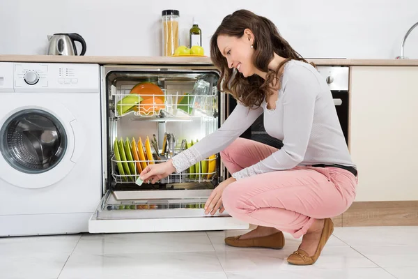 家庭で食器洗い機の洗剤タブレットを入れて幸せな女 — ストック写真