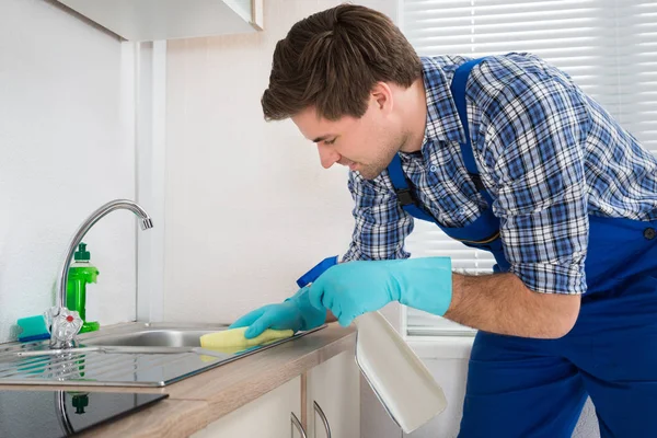 Young Happy Male Janitor Cleaning Induction Stove Kitchen — Stock Photo, Image