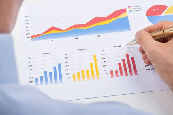 紙の上でカラフルなグラフを分析するビジネスマンのクローズアップ — ストック写真