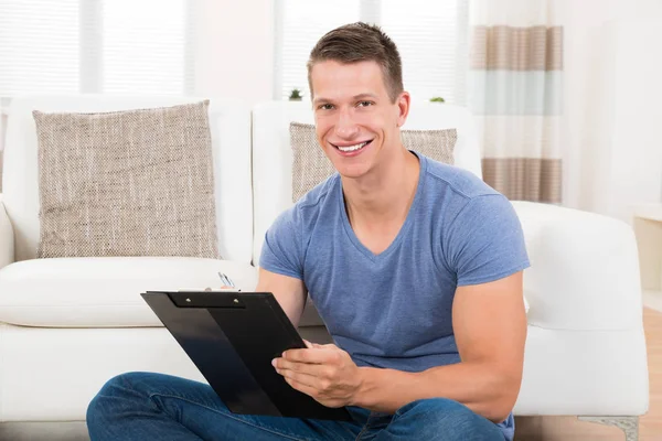 Young Man Writing Clipboard Home — Stock Photo, Image