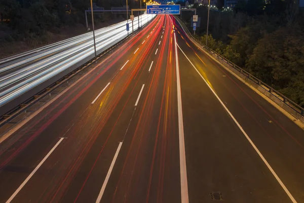 シティセンターやラジオ塔に向かって夜に光の帯を持つ街の高速道路の夜景 — ストック写真