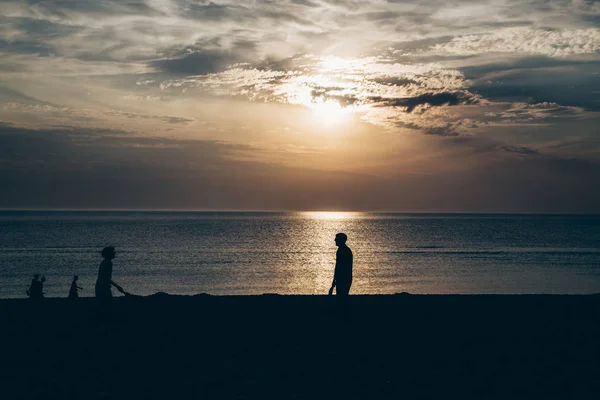 Wieczorne Słońce Morzu Sylwetkami Ludzi Podświetleniu — Zdjęcie stockowe