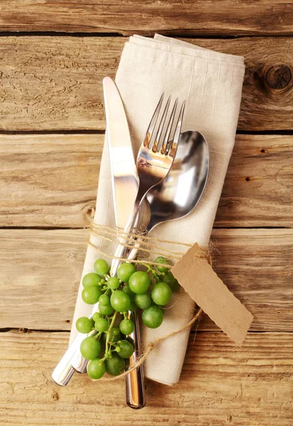 素朴な木製ボード上のフォーク ナイフやスプーンのカトラリーと装飾的なワイン祭りのシンボル — ストック写真