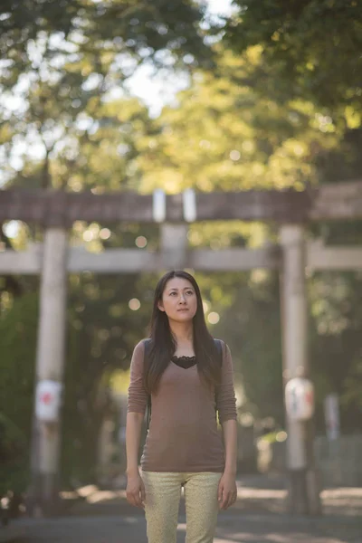 Ένα Νεαρό Ιαπωνικό Κορίτσι Στέκεται Μπροστά Από Μια Πέτρινη Πύλη — Φωτογραφία Αρχείου