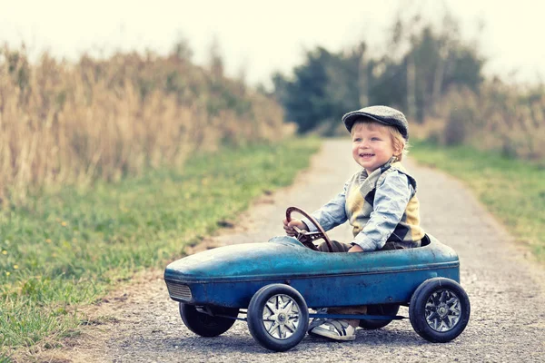 laughing boy with his pedal car