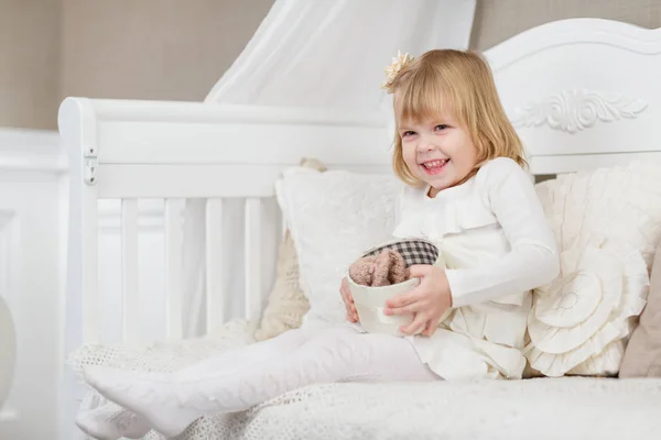 Glückliches Kleines Hübsches Mädchen Mit Geschenkbox Sitzt Auf Einem Sofa — Stockfoto