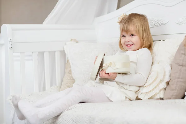 Glückliches Kleines Hübsches Mädchen Mit Geschenkbox Sitzt Auf Einem Sofa — Stockfoto