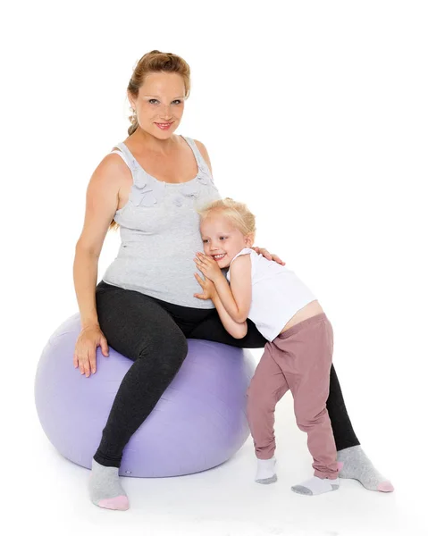 年轻的孕妇和带着健康球带着白色背景的小女儿 健康的家庭 — 图库照片