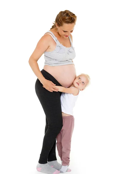 在白色背景下拥抱怀孕母亲的小女孩 快乐的家庭 — 图库照片