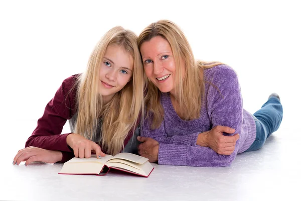 Ragazza Bionda Sua Madre Sdraiata Sul Pavimento Leggendo Libro Foto Stock