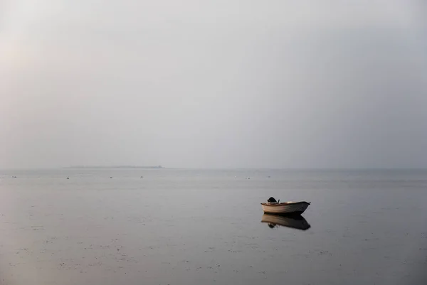 霧に包まれた海岸にはボートが一隻 — ストック写真