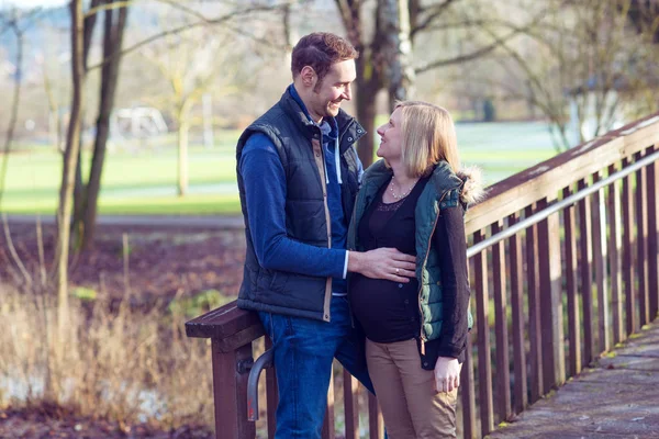 公園で夫と妊娠中の若い女性が — ストック写真