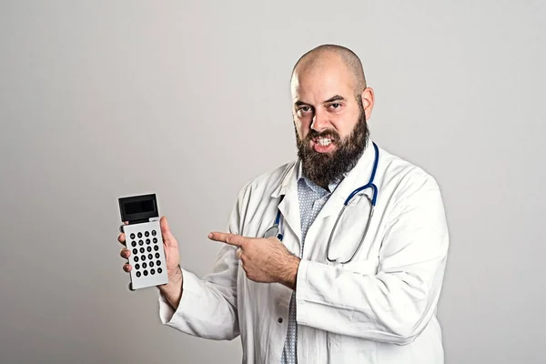 年轻的胡子医生指着袖珍计算器 — 图库照片