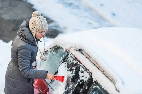 在一个冬天的早晨 清洗她的车从雪和霜的年轻女子她冻结 需要去上班 — 图库照片