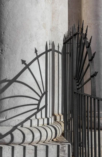 A classical column with shadows of the protective railing, concept of solidity and stability.