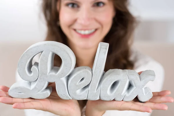 Frau Sitzt Ihrem Wohnzimmer Und Hält Einen Relax Schriftzug Der — Stockfoto