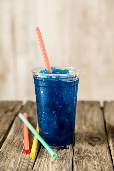 塑料杯冷冻蓝果冻饮料在生气勃勃 色泽鲜红 色泽艳丽的木桌上的静物形象 — 图库照片